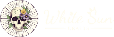 A radiant white sun and a skull decorated with yellow and purple flowers in the center. On the right is the text logo for White Sun Crafts written in cursive font, featuring a skull for the dotted 'i' in 'White' and petal-shaped sun rays radiating from the 'S' in 'Sun'.